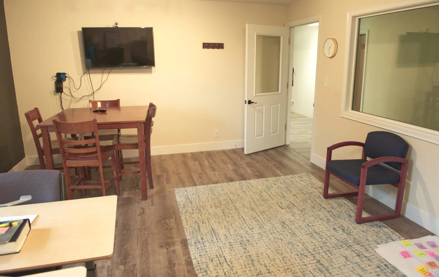 Office space for rent in St. Johns, Portland, with a table, chairs and wall-mounted screen